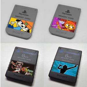 Può includere: Quattro memory card PlayStation. Due schede grigie PlayStation 1 con illustrazioni colorate di personaggi. Due schede nere PlayStation 2 con illustrazioni e il testo "8MB Memory Card". Tutte le schede hanno il logo Sony.