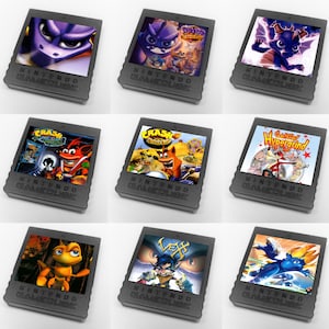 May include: Nine Nintendo GameCube game cartridges are displayed, each featuring colorful game art. The cartridges are dark gray with the words "NINTENDO GAMECUBE" printed on them. The game art includes characters and titles like "Crash Bandicoot" and "Spyro."