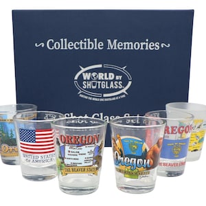 Peut inclure: Un ensemble de verres à shot transparents avec des motifs colorés et le mot "Oregon". Les verres présentent des images du drapeau de l'Oregon, une carte et le texte "United States of America". L'ensemble est présenté dans une boîte bleu marine avec le texte "Collectible Memories".