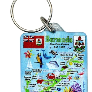 May include: A Bermuda souvenir keychain with a map design. The keychain features the Bermuda flag, coat of arms, and a detailed map with various locations and illustrations of marine life. The text "Bermuda" and "Quo Fata Ferunt Est. 1503" are also visible.