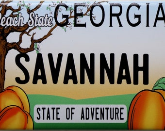 May include: A white and blue magnet with a peach tree and the text "Peach State Georgia Savannah State of Adventure".