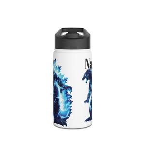 May include: White water bottle with a black lid featuring a blue and black graphic of a monster with lightning effects. The word "Na" is printed in black on the side of the bottle. The bottle is designed for cold beverages.