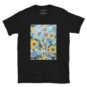 May include: Black t-shirt featuring a floral print with blue, yellow and white flowers. The print is a stylised design of a tree with flowers and leaves.