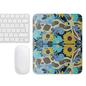 May include: A mouse pad with a colorful floral design featuring a snake winding through the flowers. The flowers are yellow, blue, and green on a black background.