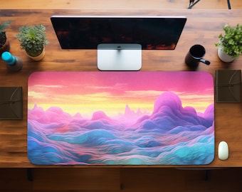 Puede incluir: Alfombrilla de escritorio rectangular con un diseño de paisaje abstracto. La obra de arte muestra un degradado de colores rosa, morado, amarillo y azul, que recuerda a una puesta de sol sobre colinas. Se ven un monitor de ordenador, un ratón y otros accesorios de escritorio.