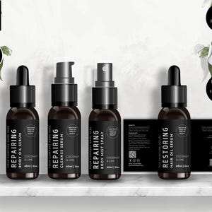 May include: Four black bottles with white labels and black text. The labels read "Repairing Body Oil Serum", "Repairing Cleanse Serum", "Repairing Body Mist Spray", and "Restoring Hair Oil Serum". Each bottle has a black dropper or spray top and is labelled with "Coconut & Lime" and "60ml | 2oz".