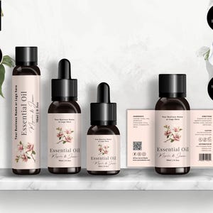 May include: An image of essential oil bottles with black caps and labels. The labels feature the text "Essential Oil" and a floral design. The image also includes a label with ingredients and directions. The bottles are in different sizes, including 10ml and 15ml.