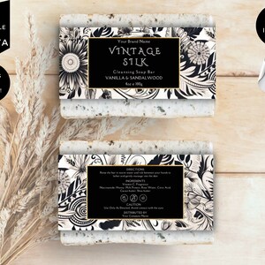 May include: A black and white soap bar label with gold accents. The label features a floral design and the text "Vintage Silk Cleansing Soap Bar Vanilla & Sandalwood 4oz e 100g".