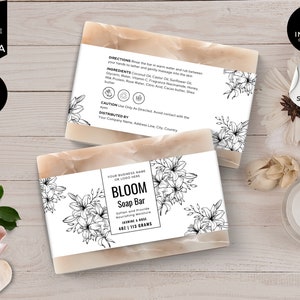 Peut inclure: Une barre de savon rectangulaire blanche avec un motif floral noir et blanc et le texte "BLOOM Soap Bar" sur l'étiquette. L'étiquette comprend également le texte "Soften and Provide Nourishing Moisture" et "Jasmine & Rose 4oz | 113 Grams".