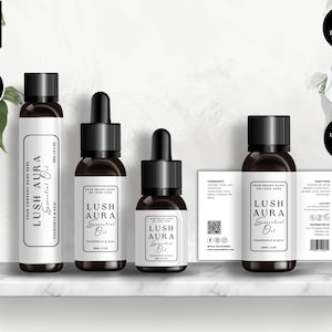 Pode incluir: Quatro garrafas de vidro castanho com conta-gotas e etiquetas brancas. As etiquetas têm o texto "LUSH AURA Essential Oil" e "Chamomile & Tea Tree".