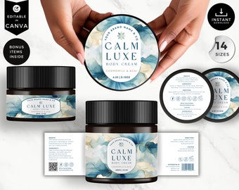 May include: A black jar with a white label featuring a blue and gold watercolor design. The label reads "Calm Luxe Body Cream Chamomile & Acai 4.25 oz / 150z".