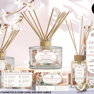 Op de afbeelding: Transparante glazen rietverspreiders met houten rietjes, met het label "Opal Aura Reed Diffuser Honey Champagne". Inclusief bedank- en verzorgingskaarten en etiketten. De flessen zijn 120 ml.