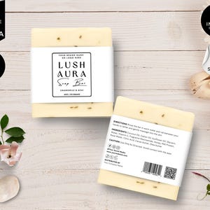 Puede incluir: Dos barras rectangulares de jabón con la marca Lush Aura, manzanilla y acai, e información sobre los ingredientes. El jabón es de color amarillo claro con pequeñas motas. El embalaje incluye el texto "Editable in Canva" y "Bonus Items Inside!"