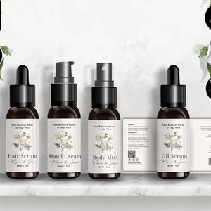 May include: Four brown glass bottles with black droppers and sprayers, labelled Hair Serum, Hand Cream, Body Mist, and Oil Serum. Each label features a floral design and the text "Magnolia & Jasmine". The image includes text that says "Editable in Canva" and "Instant Download".