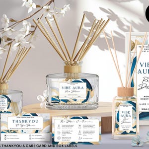 May include: A set of three reed diffusers with blue and gold labels. The labels say "Vibe Aura Reed Diffuser" and "Honey Champagne". The diffusers are 120 ml / 4 oz. The set also includes a thank you card and a care card.