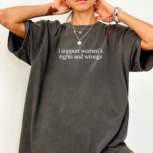 May include: A dark gray oversized t-shirt with the text "i support women's rights and wrongs" printed on the front.