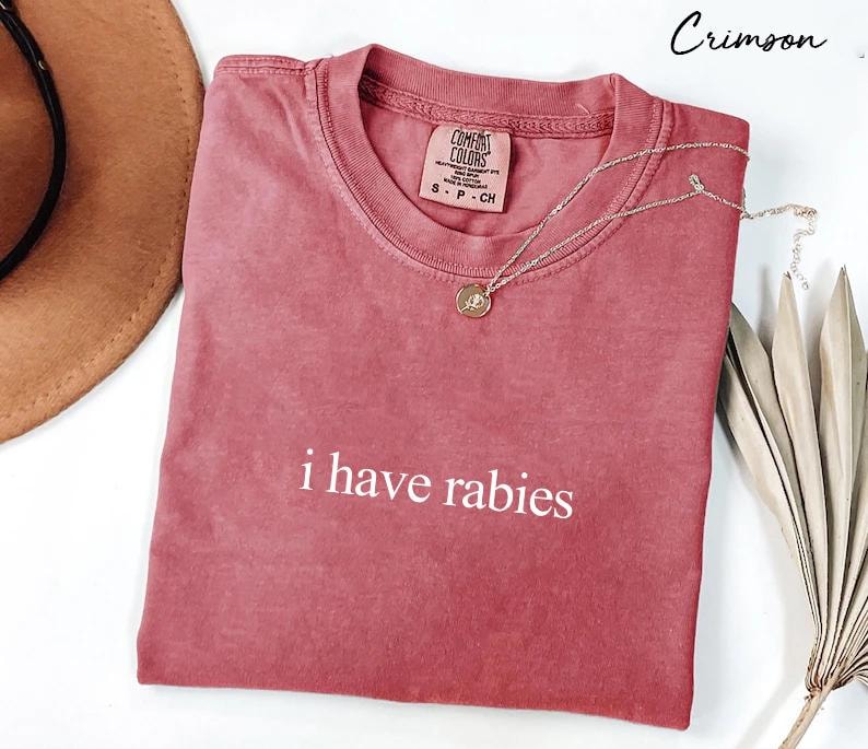 May include: Crimson red t-shirt with the text "i have rabies" printed in white. The shirt is made of a soft, comfortable material and has a relaxed fit.