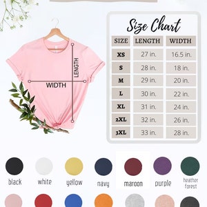 May include: Unisex t-shirt size chart with measurements in inches. The chart shows the length and width of the shirt in sizes XS to 3XL. The chart is displayed on a white background with a pink t-shirt hanging on a wooden hanger.