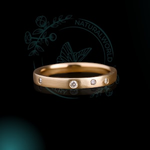 May include: A simple gold band with a brushed finish and five small diamonds set into the band.