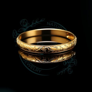 May include: A gold bangle bracelet with a floral design. The bracelet is smooth and shiny.