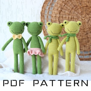 Könnte beinhalten: Vier handgefertigte Häkelfroschpuppen in verschiedenen Grün- und Gelbtönen. Zwei Frösche haben Fliegen, einer hat einen rosa Rock und zwei haben grüne Schals. Der Text "PDF PATTERN" steht unten.