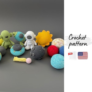 Könnte beinhalten: Eine Sammlung von gehäkelten Spielzeugen zum Thema Weltraum, darunter ein Astronaut, eine Sonne, Planeten und eine Rakete. Die Spielzeuge sind in verschiedenen Farben wie Gelb, Blau, Rot und Grün gehalten. Der Text "Crochet pattern" ist ebenfalls vorhanden.