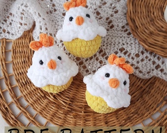 May include: Three crocheted chick toys with white bodies and yellow crocheted eggs. The chicks have orange beaks and combs.