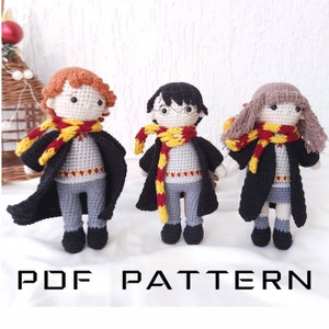 May include: Three crocheted amigurumi dolls of Harry Potter characters: Harry Potter, Ron Weasley, and Hermione Granger. The dolls are wearing their Hogwarts school uniforms and scarves. The dolls are standing on a white surface. PDF PATTERN.