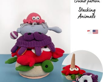 May include: A stack of handmade crochet animals, including a red crab, purple crab, gray whale, and pink octopus. The base is a turtle. The image includes the text "Crochet pattern Stacking Animals".