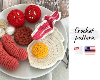 May include: A plate of crocheted breakfast food, including two red tomato halves, bacon, a fried egg, sausage links, and a burger patty. The text "Crochet pattern" is visible.