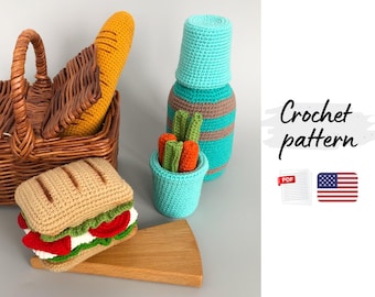 May include: A crochet picnic scene featuring a sandwich, baguette, and a basket. A turquoise container holds carrot and celery sticks. A turquoise and brown bottle is also present. The words "Crochet pattern" are visible.