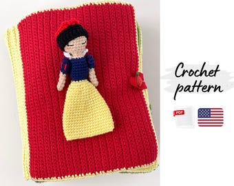 May include: A handmade crochet pattern featuring a red book-shaped cover with a yellow border. A Snow White doll is attached to the cover. The text "Crochet pattern" is displayed on the right side of the image.