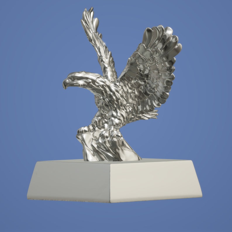 May include: A silver eagle statue with wings spread, perched on a rock, mounted on a square base.