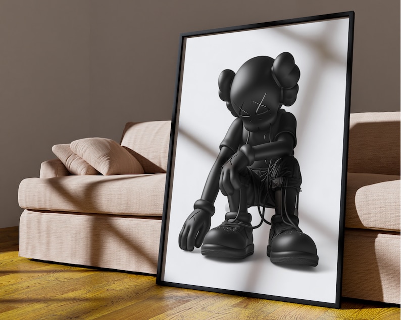 Puede incluir: Ilustraci&oacute;n en blanco y negro de un personaje de dibujos animados con una cabeza grande y un cuerpo peque&ntilde;o, sentado con las piernas cruzadas y las manos sobre las rodillas. El personaje lleva una camisa y pantalones negros, y tiene una X negra en la frente.