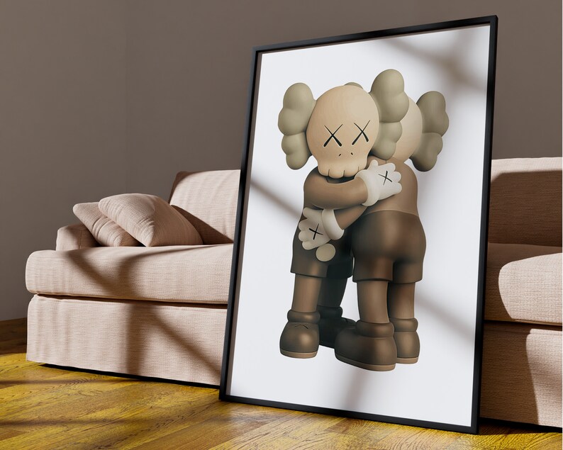 May include: A framed print of a brown and beige cartoon character with an X for eyes hugging another similar character. The background is white.