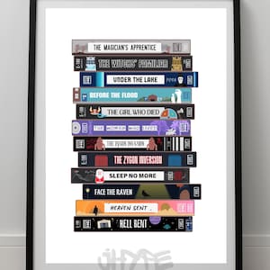 Puede incluir: Una pila de cintas VHS con títulos de episodios de Doctor Who, incluyendo "El aprendiz del mago", "La familiar de la bruja", "Bajo el lago", "Antes de la inundación", "La chica que murió", "La mujer que vivió", "La invasión Zygon", "La inversión Zygon", "No dormir más", "Cara al cuervo", "Cielo enviado", y "Infierno doblado".