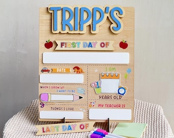 May include: Wooden first and last day of school sign with the name "Tripp's" in blue letters. The sign includes spaces to write the date, age, teacher's name, and things they love. Includes markers.