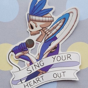 Puede incluir: Una pegatina con un esqueleto de dibujos animados que lleva un disfraz azul y blanco, sosteniendo un micrófono y cantando. La pegatina tiene una pancarta que dice "Canta con todo tu corazón".