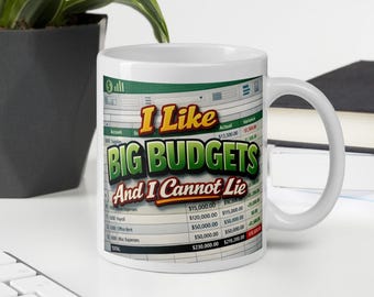 May include: White ceramic mug with the text "I Like BIG BUDGETS And I Cannot Lie" in green, orange, and yellow. The design includes a spreadsheet background. The mug has a curved handle and is suitable for hot or cold beverages.