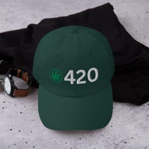 May include: A dark green baseball cap with a white embroidered number "420" and a green marijuana leaf.