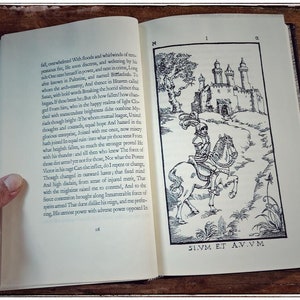 K&ouml;nnte beinhalten: Eine Schwarzwei&szlig;illustration eines Ritters auf einem Pferd, der auf ein Schloss mit T&uuml;rmen zu reitet. Der Text "SIVM ET AV.VM" ist unter dem Bild gedruckt.