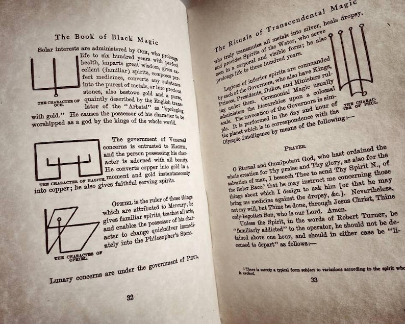 May include: A page from a book titled "The Book of Black Magic" with black and white illustrations of symbols. The text describes the symbols and their meanings. The text includes the words "The Character of Oct", "The Character of Ragite", "The Character of Ophiel", and "The Rituals of Transcendental Magic".