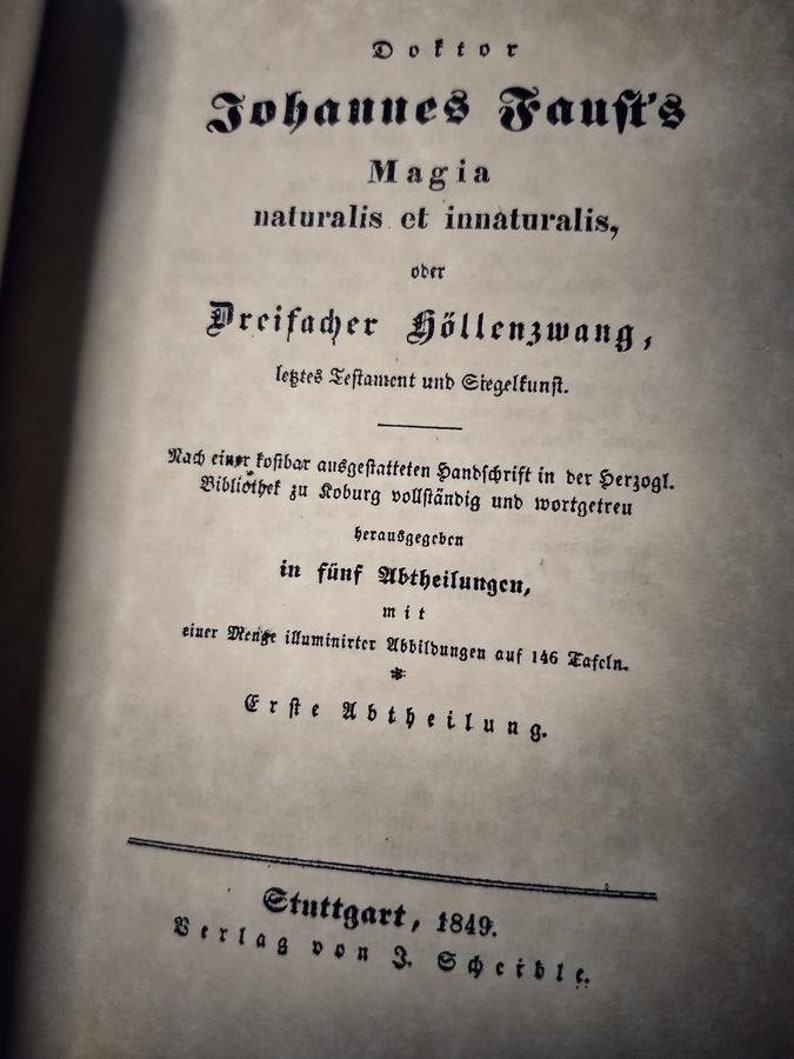 K&ouml;nnte beinhalten: Eine alte Buchseite mit deutschem Text. Der Titel, in gotischer Schrift, lautet "Johannes Faust's Magia naturalis et innaturalis". Die Seite ist gealtert, mit dem Erscheinungsjahr 1849 unten. Der Text ist verblasst und das Papier abgenutzt.