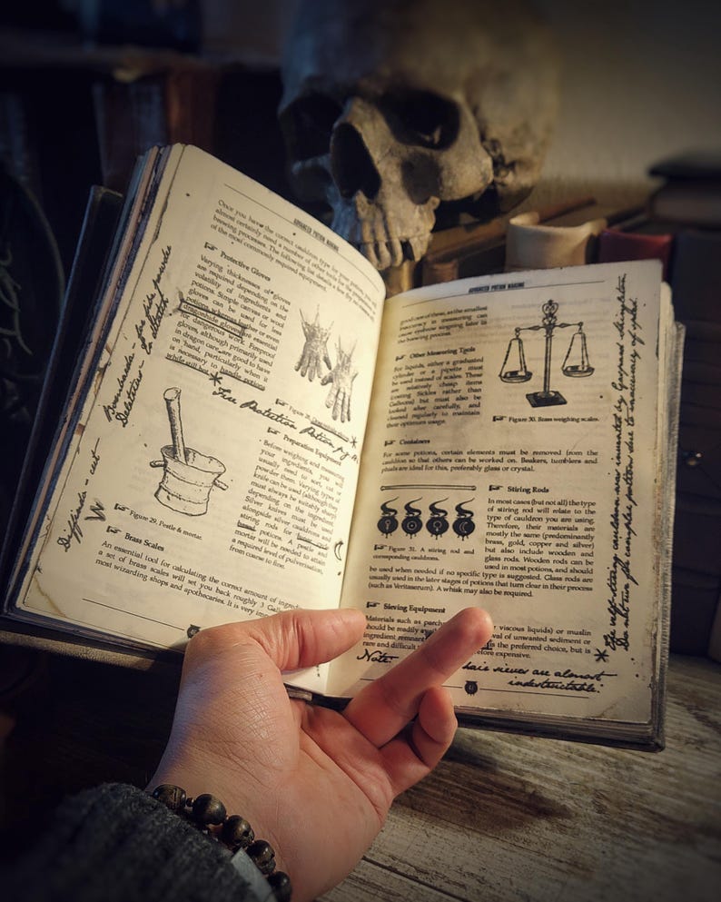 Op de afbeelding: Open boek met illustraties en tekst over het maken van drankjes, weegschalen en andere gereedschappen. Het boek is open op een pagina met de titel "Vuurbeschermingsdrank".