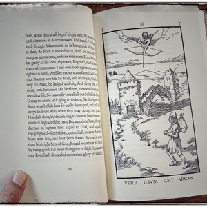 K&ouml;nnte beinhalten: Eine Schwarzwei&szlig;illustration eines Mannes mit einem Sack auf dem R&uuml;cken, der auf ein Schloss zugeht. Das Schloss hat ein Tor und einen Turm. &Uuml;ber dem Schloss fliegt eine gefl&uuml;gelte Figur mit Bogen und Pfeil durch die Wolken. Der Text "VERB. D.SVM CST ARCAN" ist unter der Illustration gedruckt.