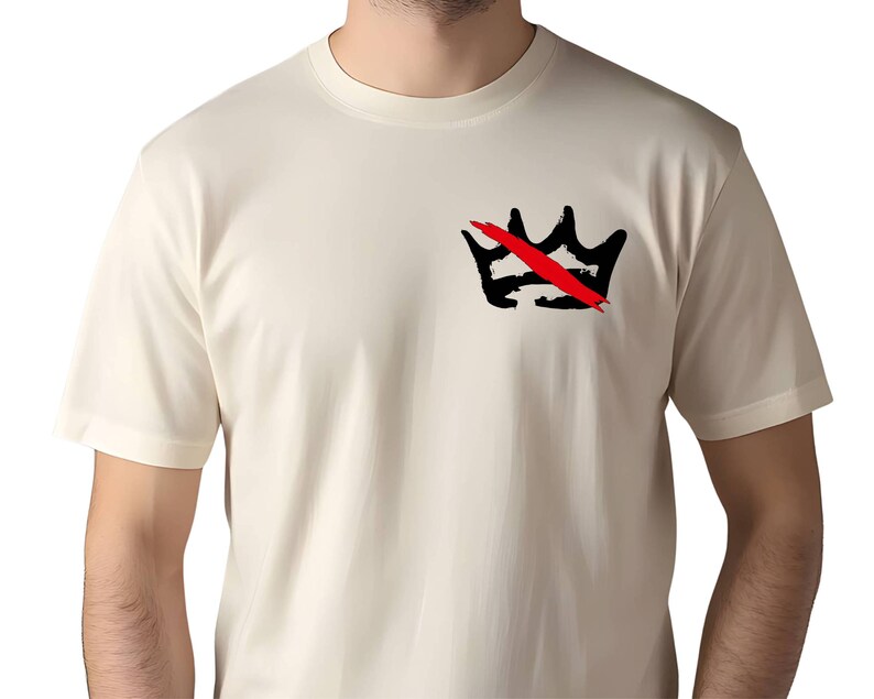 Peut inclure: T-shirt cr&egrave;me avec un motif de couronne noire barr&eacute;e d'un trait rouge. Le motif est situ&eacute; sur la poitrine gauche. Le t-shirt a des manches courtes et un col rond.