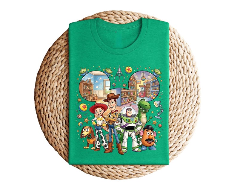 Pode incluir: Uma camiseta verde com um gr&aacute;fico colorido dos personagens de Toy Story. O design apresenta Woody, Buzz Lightyear, Jessie, Rex, Sr. Batata e Slinky Dog, com um fundo detalhado de uma loja de brinquedos.