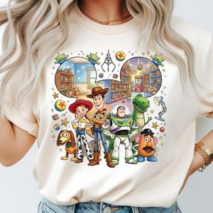 Pode incluir: Camiseta creme com um gr&aacute;fico colorido dos personagens de Toy Story, incluindo Woody, Buzz Lightyear e Rex. O design inclui uma ilustra&ccedil;&atilde;o detalhada de uma loja de brinquedos e os ic&ocirc;nicos personagens alien&iacute;genas. A camiseta &eacute; de gola redonda.