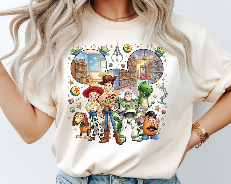 Pode incluir: Camiseta creme com um gr&aacute;fico colorido dos personagens de Toy Story, incluindo Woody, Buzz Lightyear e Rex. O design inclui uma ilustra&ccedil;&atilde;o detalhada de uma loja de brinquedos e os ic&ocirc;nicos personagens alien&iacute;genas. A camiseta &eacute; de gola redonda.