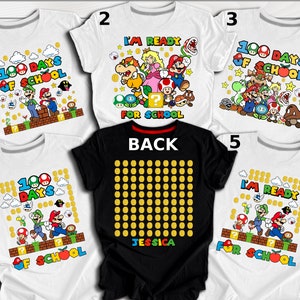 Puede incluir: Cinco camisetas blancas con un tema de 100 d&iacute;as de escuela con personajes de Mario y Luigi. Una camiseta negra con un patr&oacute;n de monedas de oro y el texto "BACK" y "JESSICA".